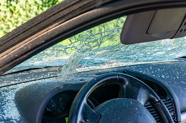 istock Cracked and shattered car windshield after a road accident, interior view showing steering wheel and dashboard covered with small glass fragments and debris 2242706093