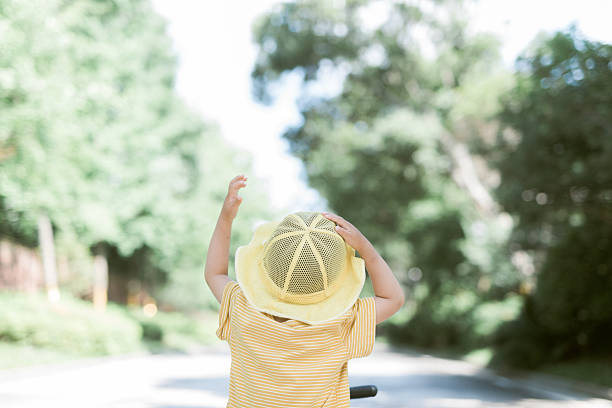 Cute Child in Sun Hat on Tricycle in Outdoor Setting