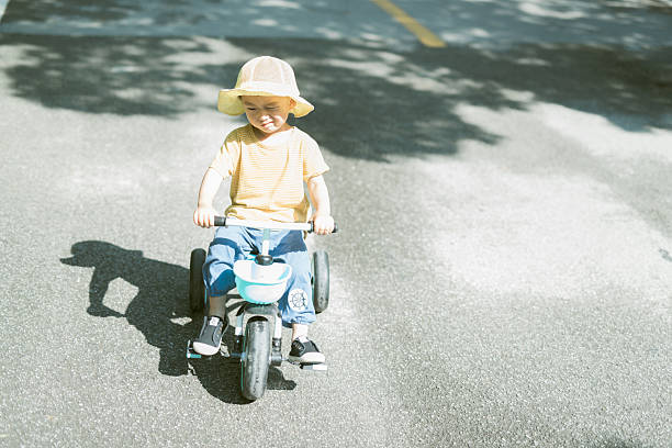 Smiling Toddler on Tricycle Under Shady Trees
