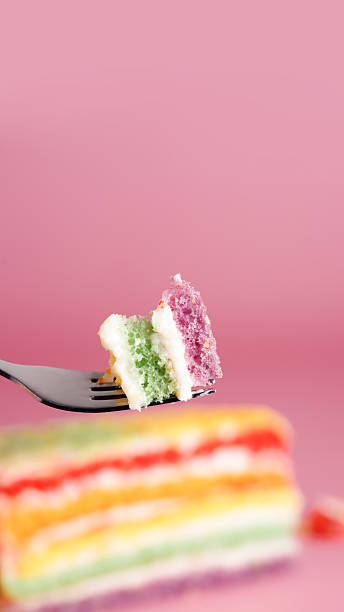 istock Piece of colorful layered cake on fork, dessert composition with copy space, 9:16. 2242717360