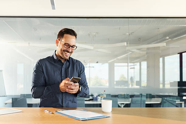 istock Happy businessman using mobile phone in the office. 2242720688
