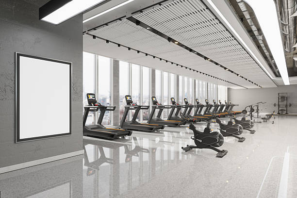 istock Modern Gym Interior with Exercise Equipment and Blank Advertising Billboard 2242721583