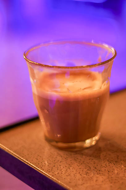 Close-up of a warm milk coffee beverage in a small glass cup