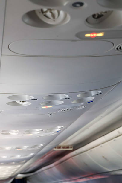 Close-up of an airplane passenger service unit (PSU) on the cabin ceiling, featuring individual air vents, reading lights, a \