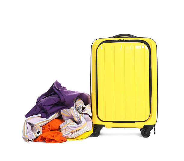 istock Suitcase and messy pile of clothes isolated on white 2242725262