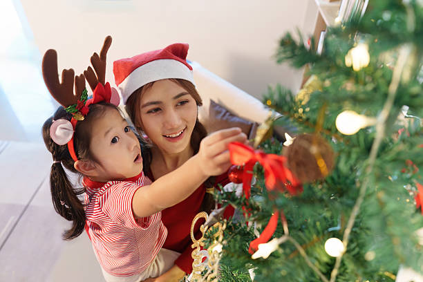 istock Christmas Tree Decorating. A mother and daughter joyfully decorate their Christmas tree. 2242727170