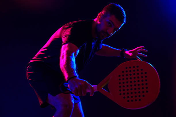 istock Player practices padel at night under vibrant lighting in indoor court 2242727344