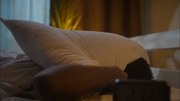 istock Stressed exhausted African American ethnic man guy male lying on bed suffering insomnia disorder can't sleep awake bad sleeping nap trouble napping stress health problems at home bedroom late night 2242736518