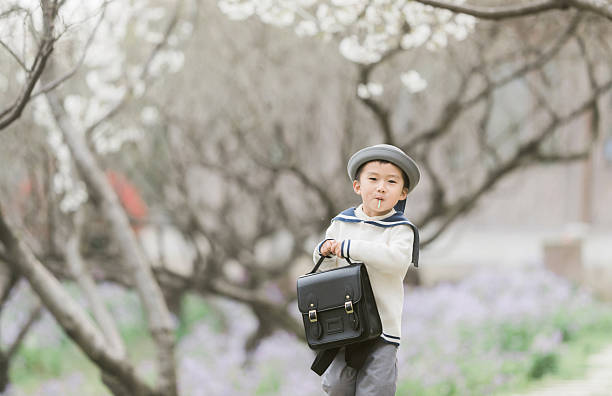 a smiling boy in a blooming garden, a happy child next to a blossoming tree