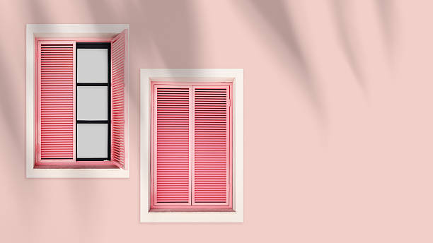 istock Minimal summer aesthetic pink shutter windows on pastel pink wall. Natural sunlight palm leaf shadows, modern monochrome design banner. Concepts of summer, vacation, tropical style architecture 2242744742