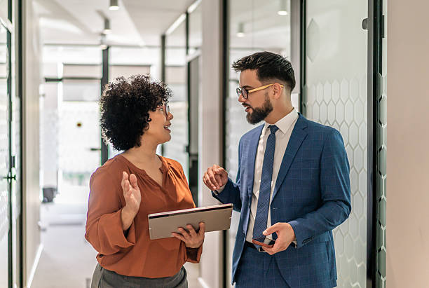 istock Business colleagues having discussion walking in office hallway 2242747141