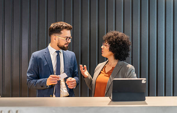 istock Business colleagues talking, exchanging business card at reception 2242747247