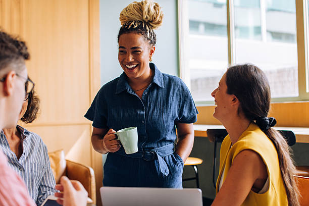 istock Smiling colleagues sharing a conversation during a casual workspace moment together 2242749447