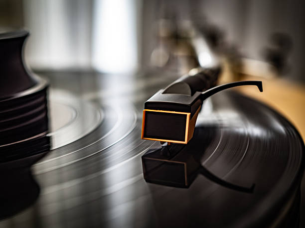 A close-up of a spinning vinyl record on a turntable, capturing the motion of grooves and the stylus. Classic analog music setup evokes nostalgia, creativity, and warm sound.