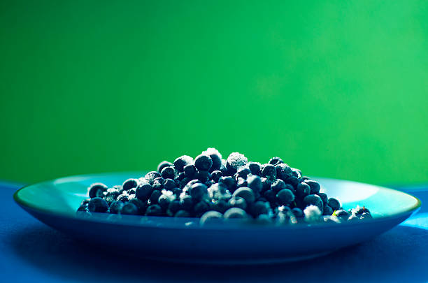 close-up of the ripe blueberries covered with ice lying on a plate