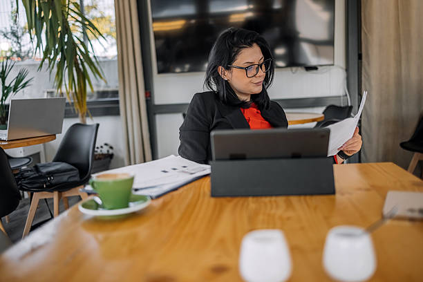 istock Young businesswoman working using wireless technology while sitting at cafe taking a coffee break 2242753909