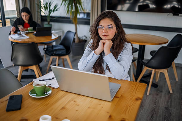 istock Young businesswoman working using wireless technology while sitting at cafe taking a coffee break 2242754082