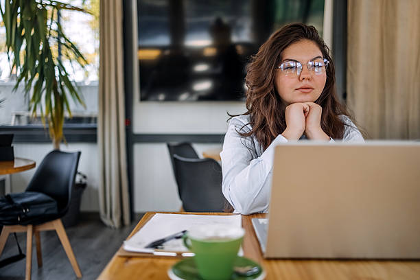 istock Young businesswoman working using wireless technology while sitting at cafe taking a coffee break 2242754087