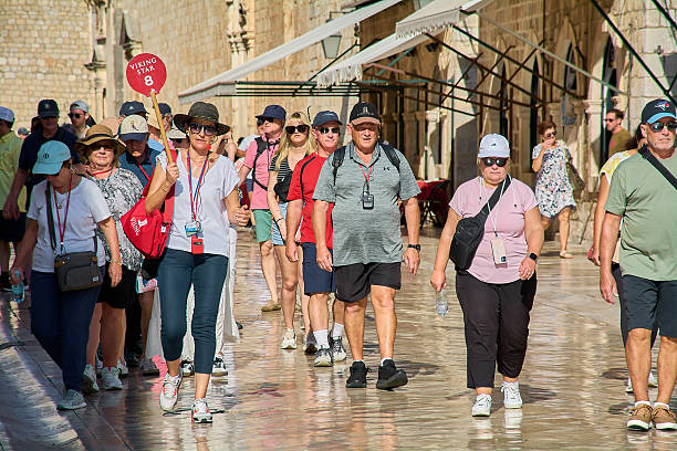 Dubrovnik. Croatia - October 23, 2025: A tour guide holding a Viking Star sign leads a group of tourists on a walking tour along the Stradun in Dubrovniks Old Town.