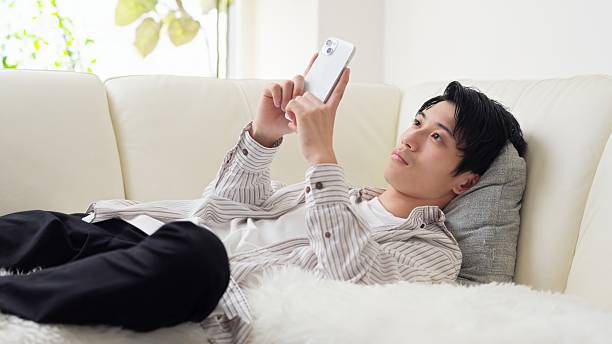 istock Asian man falling asleep while looking at his smartphone 2242756476