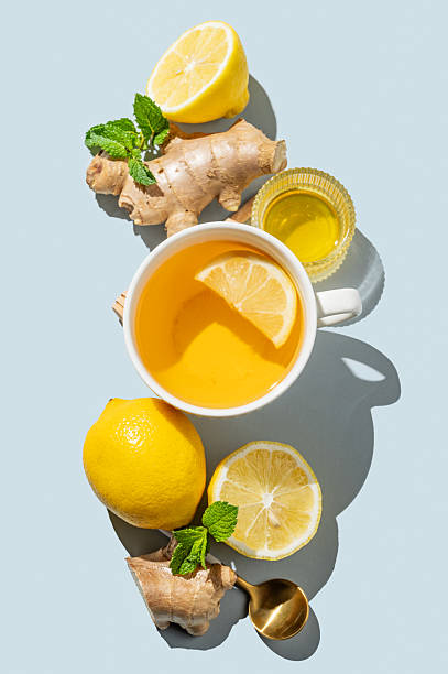 istock Creative layout of hot tea with lemon, ginger, honey, and mint in a cup on a blue background 2242756673