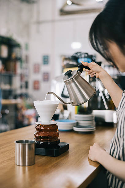 istock Barista making pour-over coffee in a modern cafe setting 2242758149