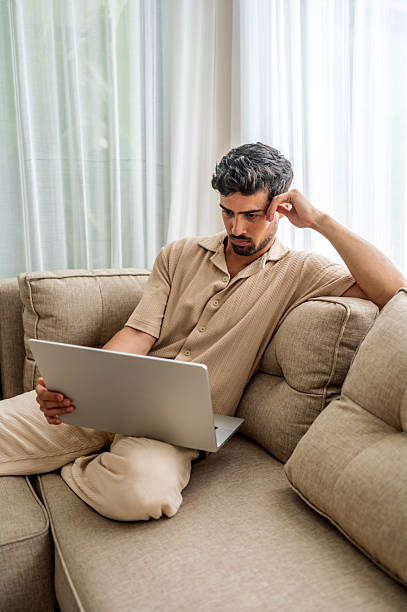 istock Man Working Peacefully on Laptop on Couch in Cozy Living Room Setting 2242760202