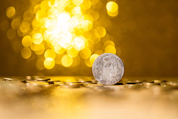 Coin with Benjamin Franklin on shiny background.