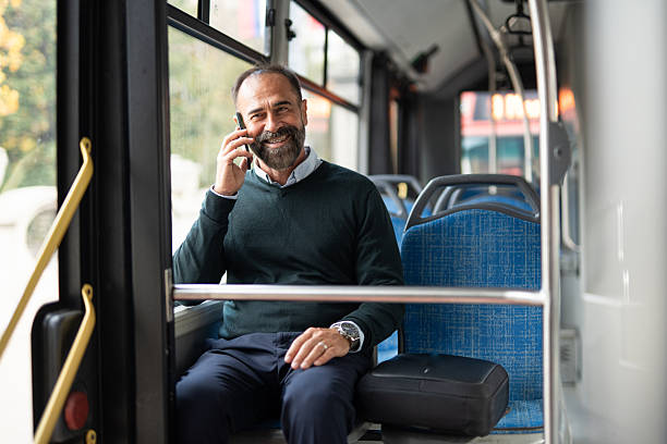 istock Smiling man talking on phone during daily bus commute 2242766502