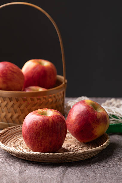 istock Red apple fruit (Envy apple) in basket on brown fabric with black background 2242767695