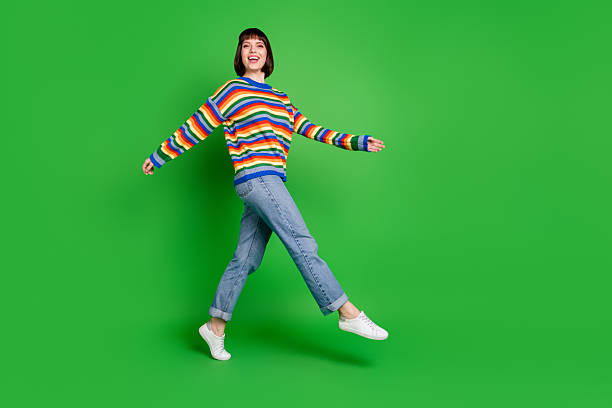 istock Full length photo of shiny charming young lady dressed colorful pullover walking smiling isolated green color background 2242768028
