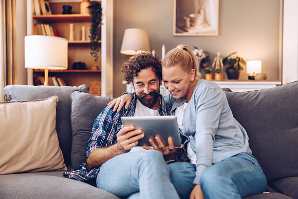 istock A couple having time to themselves, watching their memories on the digital tablet while sitting on the sofa in the living room. 2242770007