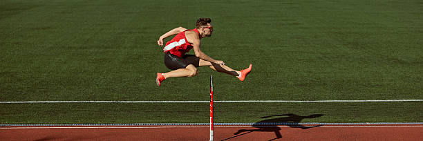 istock Hurdler jumping over barrier with power and focus during training. Banner 2242774010