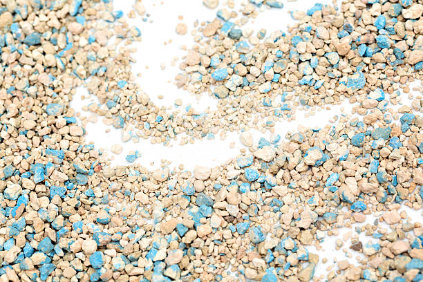 istock Textured cat litter with blue and beige pebbles scattered across a white surface in a wave pattern. It emphasizes the love for natural absorbent materials suitable for pet care. 2242774290
