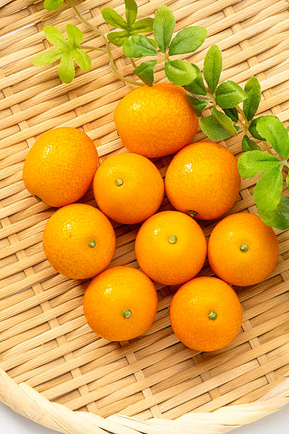 Fresh kumquats on bamboo tray
