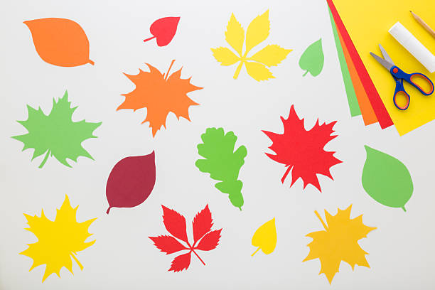 istock Created colorful different paper leaves. Application paper, scissors, glue stick and pencil on light gray table background. Closeup. Making autumn decoration. Top down view. 2242775901