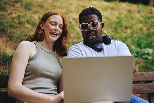 istock Coworkers smiling while working on laptop outdoors 2242775935