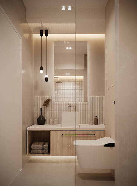 istock Modern minimalist bathroom interior with warm neutral tones and soft ambient lighting. Elegant white sanitary fixtures, textured wall tiles, light wood cabinetry, and subtle LED accents create a clean and sophisticated atmosphere. 2242776646