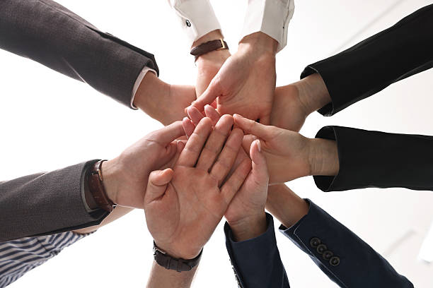 istock Teamwork. Group of people joining hands together indoors, bottom view 2242776790