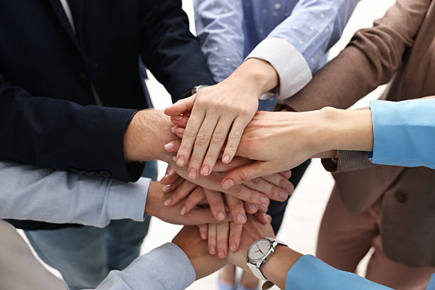istock Teamwork. Group of people joining hands together indoors, closeup 2242776796