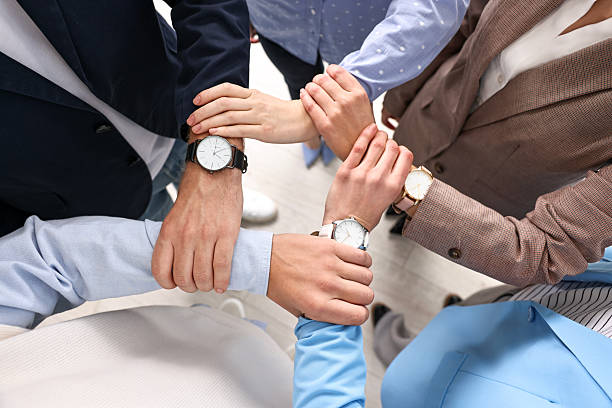 istock Teamwork. Group of people holding hands together indoors, top view 2242776808