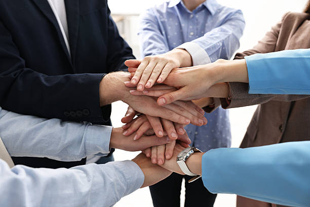 istock Teamwork. Group of people joining hands together indoors, closeup 2242776819