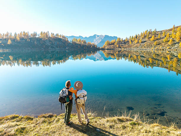 istock Couple Hiking by Mountain Lake Reflection 2242778399