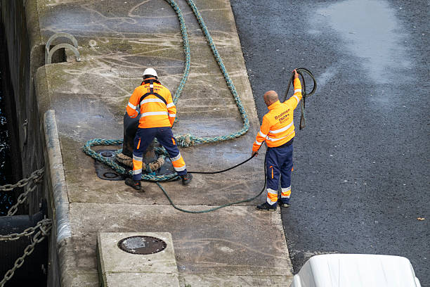 5th October, 2025 - Port workers attaching a securing rope from a cruise ship to bollards on the harbour quay in Getxo, Northern Spain