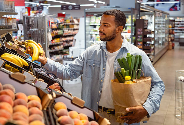 istock Engaged Shopper Choosing Bananas in Grocery Store Produce Section 2242784837