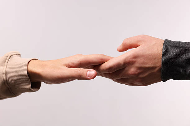 Close up of unrecognizable couple holding hands in summer day.