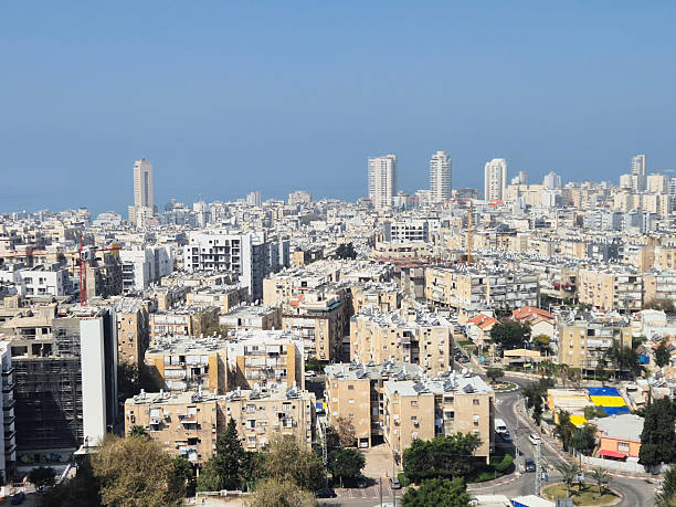 istock Urban view with densely packed buildings extending to sea horizon under blue sky, highlighting contrast between city and natural elements 2242786381