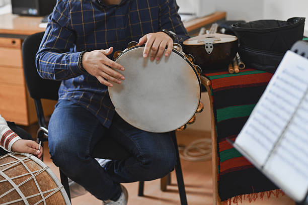 istock Male Instructor Playing Traditional Instrument With Students In Engaging Music Session 2242791973