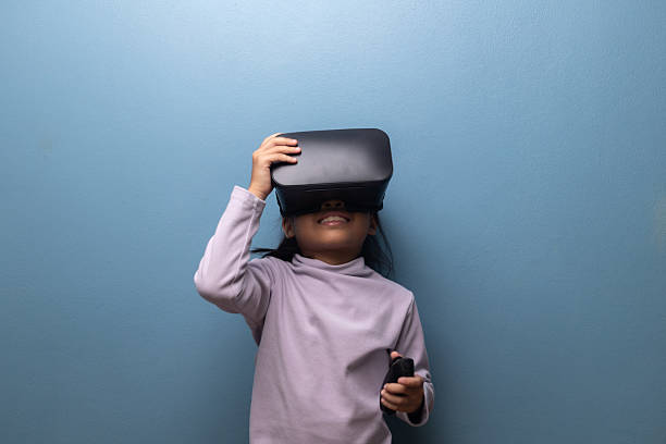 istock Young girl playing with virtual reality headset experiencing immersive digital world, concept of VR learning, metaverse, and modern technology for children. 2242792466