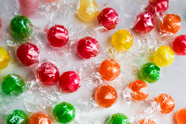 istock Assorted, individually wrapped hard candies in red, orange, yellow, and green 2242793154